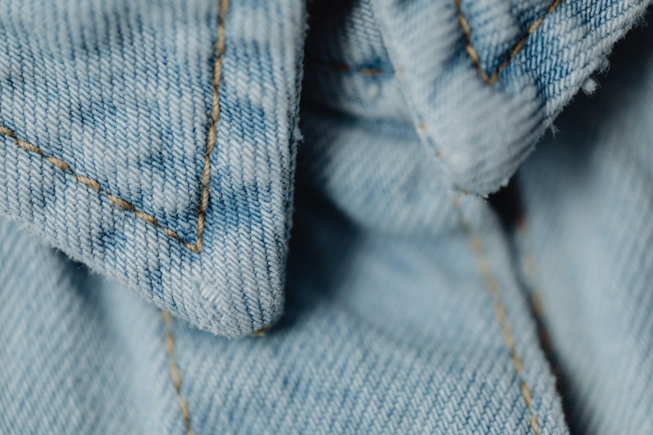 Detailed macro shot of blue denim fabric showcasing stitching and texture.